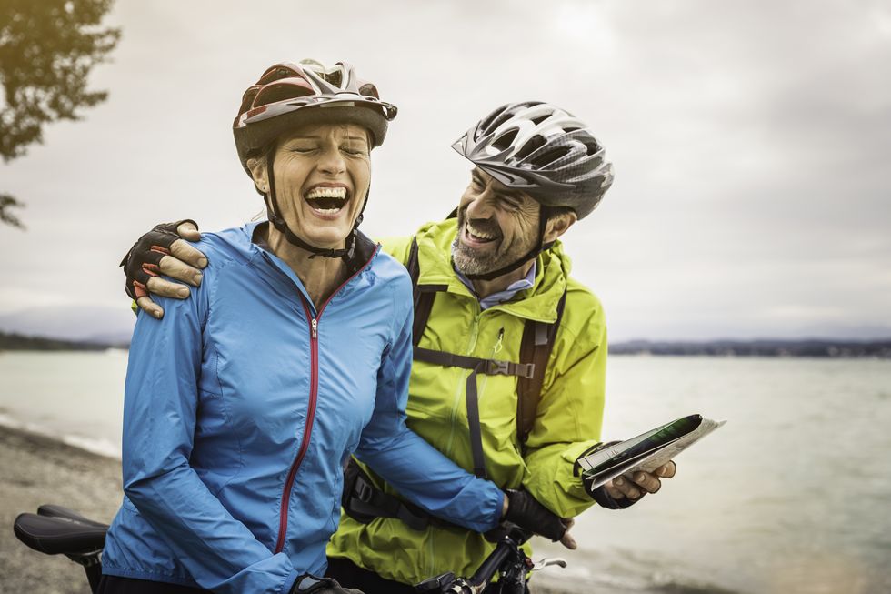 mature-mountain-biking-couple-laughing-whilst-royalty-free-image-1656100813